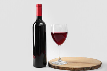 Glass and bottle of red wine on white background