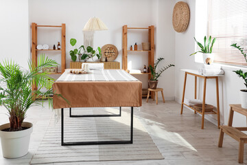 Interior of light spa salon with massage table, shelf units and plants