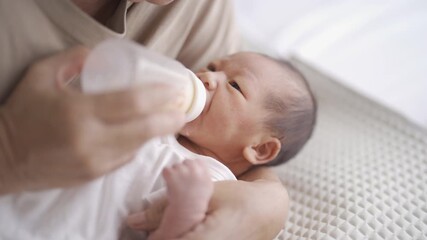 A newborn baby drinking milk at home. People lifestyle.