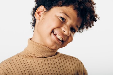 Joyful young african american girl with lively curly hair radiates happiness against a bright, simple white background