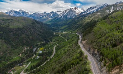Naklejka premium Winding country road, forest and snowy mountain range. Carbondale, Colorado, United States of America.
