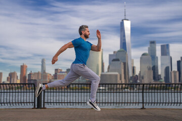 Run outdoor. Running man jogging outside in street. Mature man runner and fitness sport models training outdoor near Manhattan in New York. Millennial athlete jogging. Sports training outdoors.
