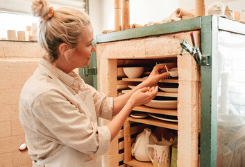 Woman, pottery and kiln for baking in studio with check, design and skills for earthenware at small...