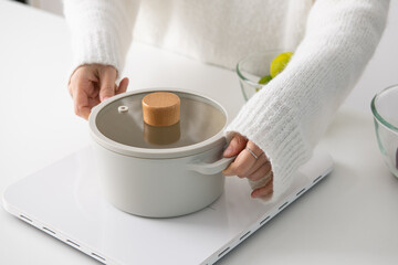 putting a white pot on the induction.