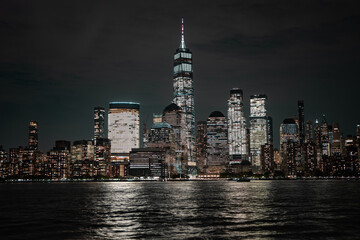Obraz premium Night in The NYC city, USA, United States. Night day with iconic buildings. New York City NYC Manhattan Downtown Skyline, viewed from Jersey City, USA.