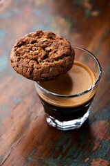 Chocolate cookie and Coffee in glass cup on rustic wooden background. Close up.
