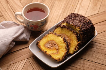 A roll cake is a sponge cake baked in a shallow pan, filled with jam or buttercream and then rolled. Roll cakes are often known as jam rolls, or jelly rolls in the United States. mocha. bolu meranti.