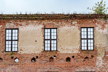 Abandoned brick building with broken windows and crumbling brickwork, neglected and derelict