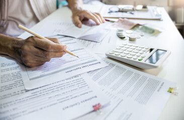 Asain man review loan applications, credit reports checking passbook to apply for loan approval to start new business