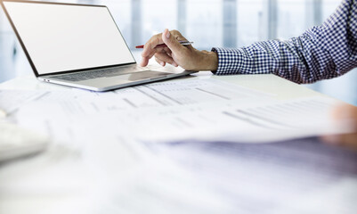 Fototapeta premium Asian businessman using computer laptop working and meeting to reviewing document report at office. legal expert, professional lawyer reading and checking financial documents or insurance contract