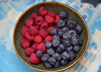 raspberries and blueberries and in a bowl