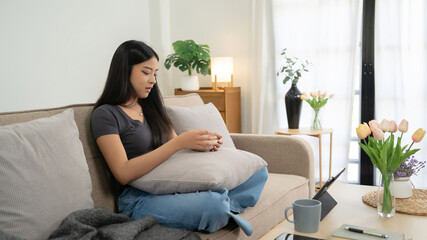 Obraz premium Young asian women watching movie entertainment and social media on digital tablet with happiness while sitting on couch to eating snack and spending time to relaxation with enjoying lifestyle at home