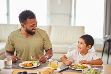 Dad, kid and happy at table for lunch, healthy food and bonding in living room. Father, boy child...