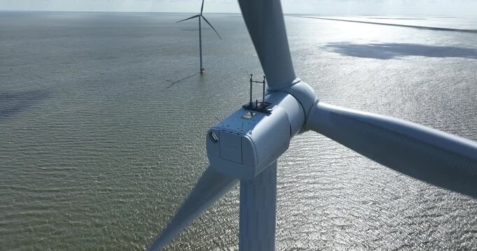 Wind turbines. Offshore wind mill park. Green sustainable energy. Wind farm at the Afsluitdijk, The Netherlands. Close up view.