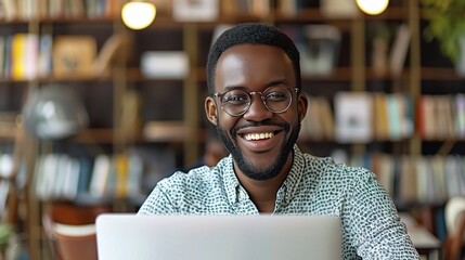 The Joy of Digital Discovery: A young black man beams with delight, captivated by the information on his laptop screen, set against the warm, inviting backdrop of a library or bookstore. 