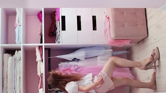 A little girl of European appearance tries on her mother's shoes in the dressing room in slow motion. A little fashionista. Fashion and style concept