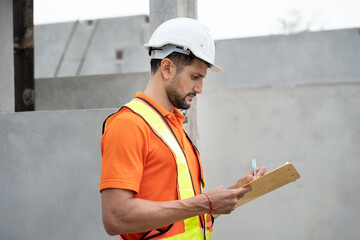 Portrait hispanic Latin engineer man use clipboard working at precast cement outdoor factory	