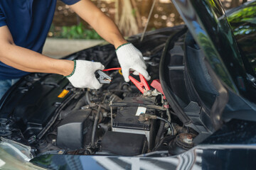 Close-up of Car mechanic noting repair parts during open car hood engine repair unrecognisable man...
