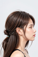 Naklejka premium Side Profile of Beautiful Asian Model - Female with Perfect and Fine Features - Perfect and Glowing Skin - Looking up in Studio Environment - Styled and Smooth Hair - Fashion or Cosmetics Model