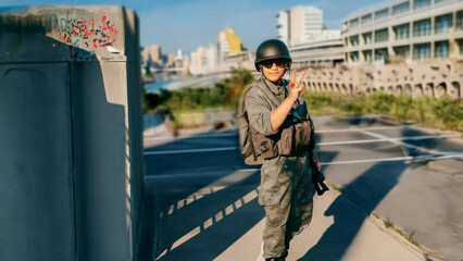 Obraz premium Short hair, sharp eyes, wearing military uniform, helmet, holding a camera, relaxed posture, smiling.