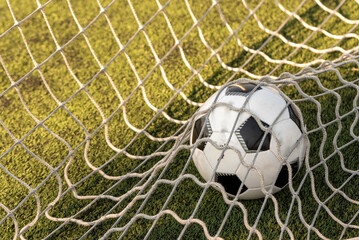 A black and white soccer ball propelled by a powerful shot, tearing through the net in a perfect goal. The bulging mesh emphasizes the impact and precision of the strike. it's for celebrating goals 