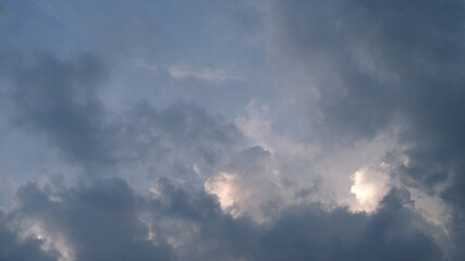 Cloud sky background with a sunset behind the horizon. Dull blue sky and clouds before rain with concepts of landscape, scene, overcast, and view for wallpaper and print. Sky texture background.