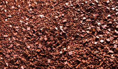 Fototapeta premium Closeup view of scattered chocolate shavings in varying shades of brown for culinary backgrounds and texture-focused food photography