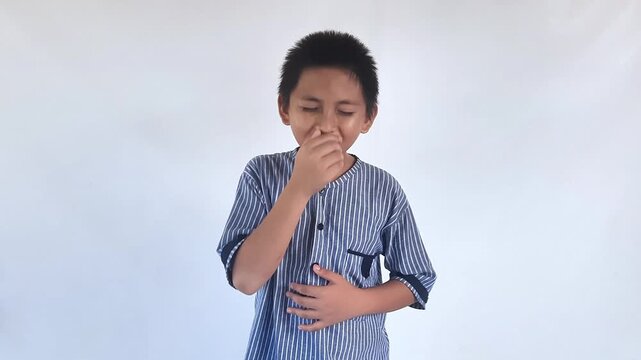 Asian little kid boy wearing blue shirt standing indoor feeling unwell and coughing as symptom for cold or bronchitis. Healthcare concept.