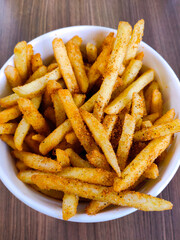 Delicious french fried with spices in a glass cup. top view