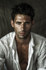Obraz premium Rugged young man staring intensely with unbuttoned shirt in natural light setting