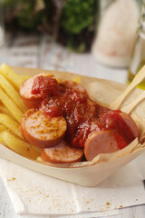 Currywurst lightly topped with curry and served with chips