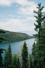 A view of a lake with a boat and a tree line in the distance