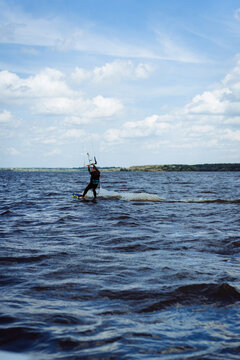 A man kitesurfs on a lake.