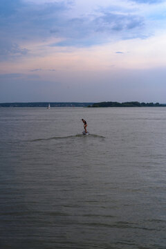 A woman rides a hydrofoil on a lake.