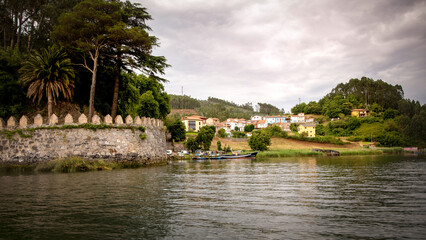 El Castillo village and pier view  from the water. Soto del Barco, Asturias, Spain.