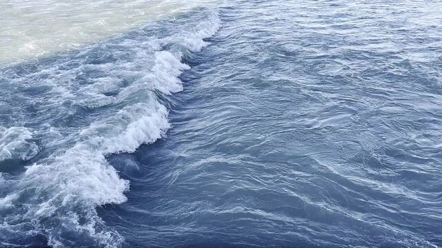 Confluence of Contrasting Waters. Turbulent Interaction of Dark Blue and Light Gray Ocean Currents in Motion. Educational documentaries videos water cuurrents and hydrodynamics
