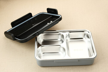 Empty Stainless Lunch box with compartments on wooden background
