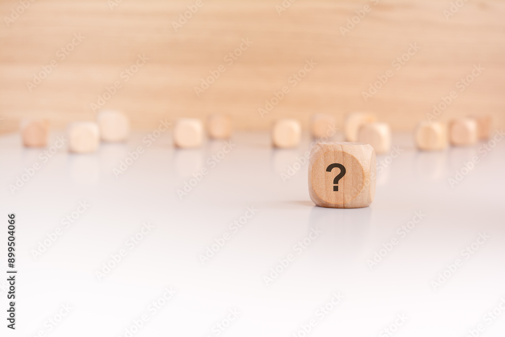 Aufkleber a wooden block with a question mark written on it. many wooden cubes out of focus in the background