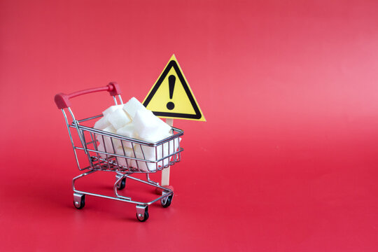 A basket filled with sugar cubes, a close-up and a warning sign "attention" on a red background