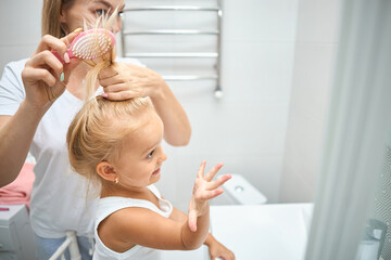 Mother and daughter child girl are combing