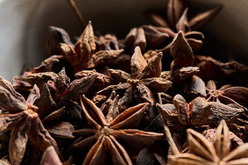 Horizontal close-up view of star anise in a bowl. 