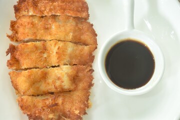 Tonkatsu crispy fried pork with flour dipping swwt soy sauce on plate
