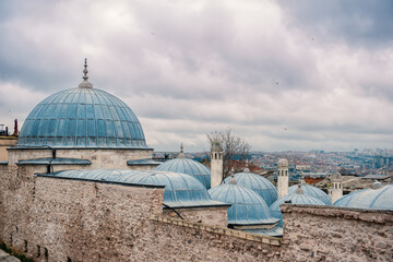 The domes of Istanbul's historical architecture stand against an overcast sky. The city's skyline...