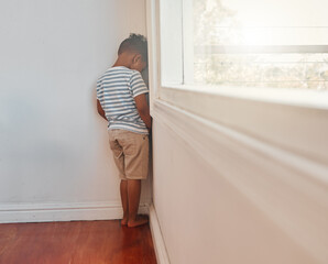 Sad, kid and punishment by wall corner for bad behavior, discipline or stress in home timeout. Boy,...