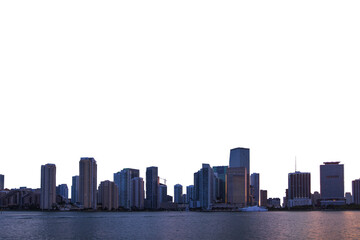 Miami skyline at dusk with illuminated buildings reflecting in the water. The cityscape is set...