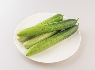 Close-up of four fresh cucumbers on white dish, South Korea
