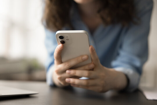 Close up view of unrecognizable woman using smartphone for browsing social media platforms, chatting with friends through messaging apps, watching videos on streaming services, playing mobile games