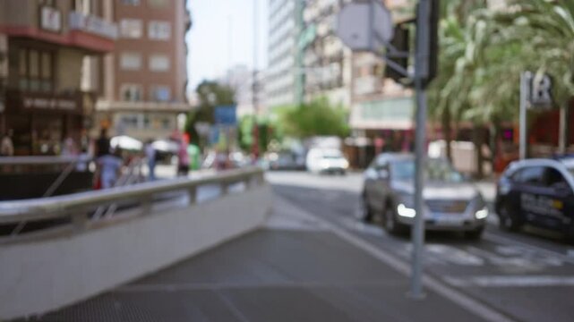 Blurry city street scene with cars and pedestrians in an urban outdoor environment with defocused buildings and traffic