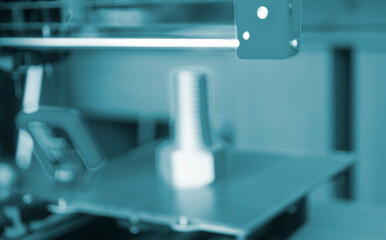 3D printer printing prototype of bolt from molten plastic. Creating prototype model of bolt on 3D printer from blue melted plastic close-up. Additive new printer technology. Blurred background
