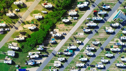 Campground office in large RV park campsite with long row of recreational vehicles and trailers...